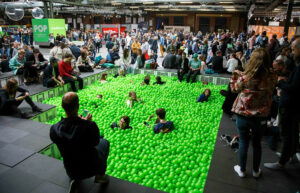 Besucher*innen im grünen Bällebad in einer Halle auf der re:publica