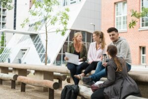 Gruppe an Studierenden sitzt vor Universitätsgebäude am Campus Berliner Tor der HAW Hamburg