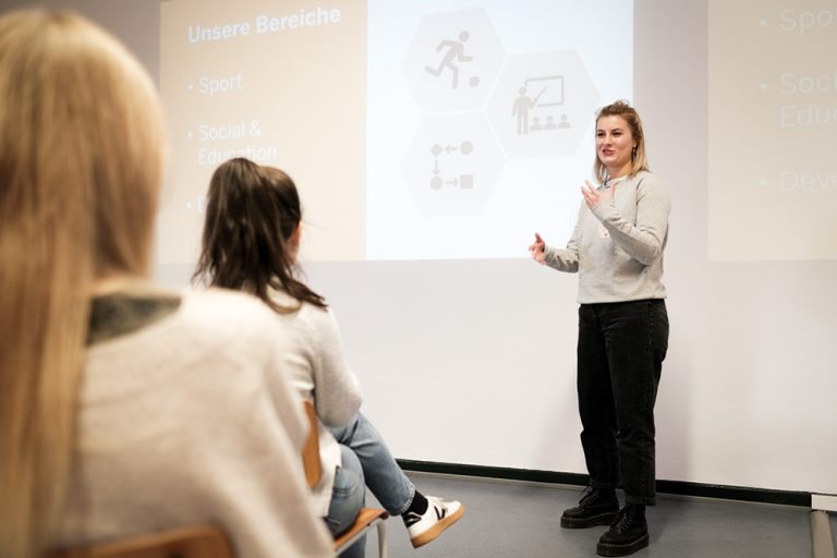 Eine Frau steht hält eine Präsentation