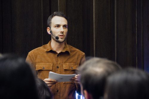 Patrick Schwarz steht vor den Besuchern und moderiert den Impactday.