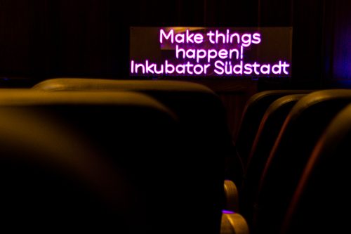 Leuchtschild mit Text: "Make things happen! Inkubator Südstadt."